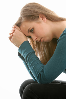 teenage depression - teen woman sitting thinking isolated on white